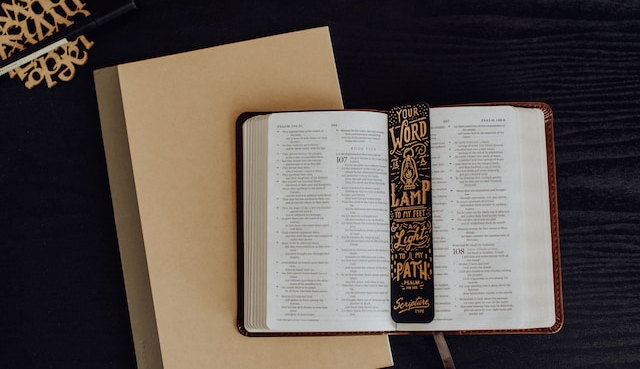 Otvorená Biblia s písacími potrebami pre komentár